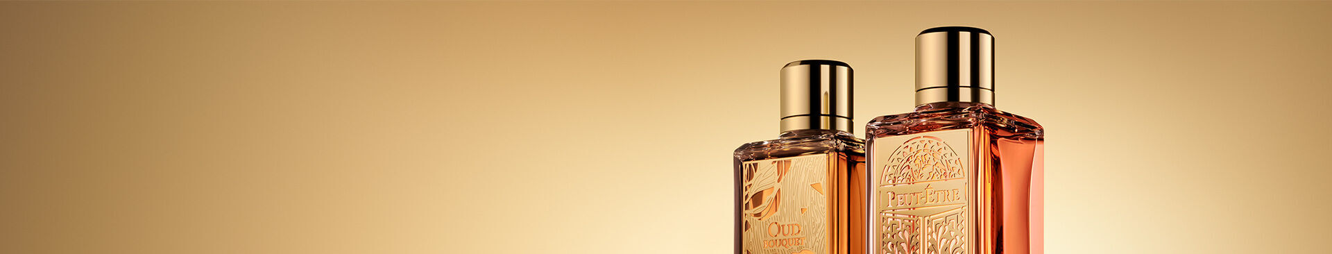 Two elegant perfume bottles are positioned against a soft golden background, showcasing their intricate designs and metallic caps.