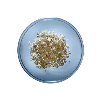 Flocon d'avoine en petits morceaux dans un bol en verre transparent sur fond clair.