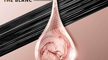 A clear drop of liquid with swirls of pink and white is shown against a soft beige background, accompanied by the text "EXTRAITS DE THE BLANC" in a bold font above. Black lines run horizontally behind the drop.