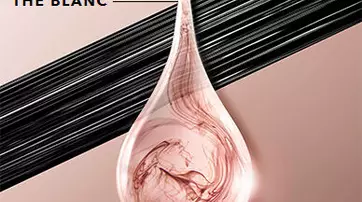 A clear drop of liquid with swirls of pink and white is shown against a soft beige background, accompanied by the text "EXTRAITS DE THE BLANC" in a bold font above. Black lines run horizontally behind the drop.