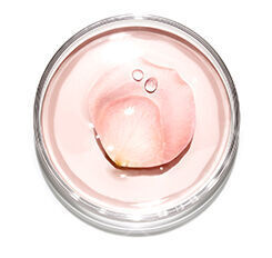 A close-up view of a clear jar containing a pale pink gel with a droplet of liquid resting on top.