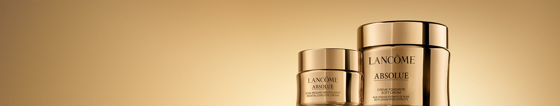 Two luxurious skincare jars from Lancome's Absolue line, featuring a gold gradient background. The jars are elegantly designed with glossy gold lids and labels.