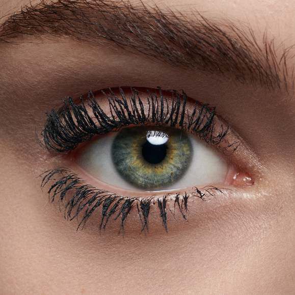 Close-up of a human eye with striking shades of green and brown, featuring thick, black eyelashes and well-defined eyebrows.