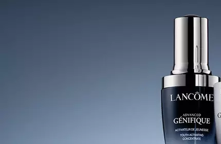 Two luxury skincare serums from Lancome on a gradient background, featuring sleek, modern packaging with silver and black accents. The products include an activating concentrate and an eye treatment.