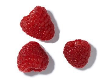 Three bright red raspberries arranged on a white background.