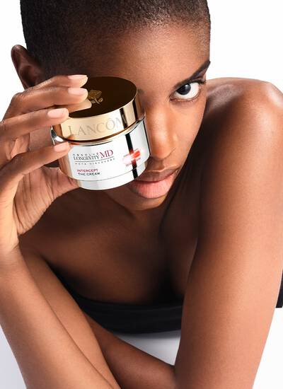 Mannequin a la peau nette presentant le pot de creme Lancome Absolue Longevity MD Intercept The Cream, un soin visage anti-age haut de gamme.