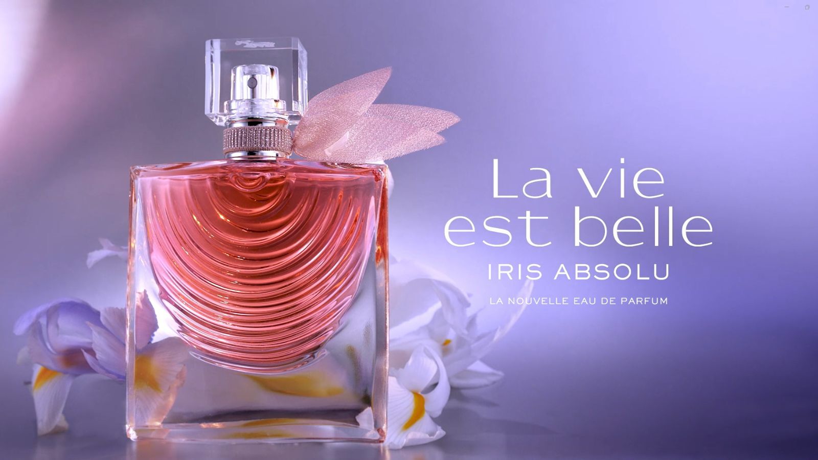 Flacon de parfum 'Iris Absolu' de La Vie est Belle, avec une teinte rose et un decor elegant, sur fond flou.
