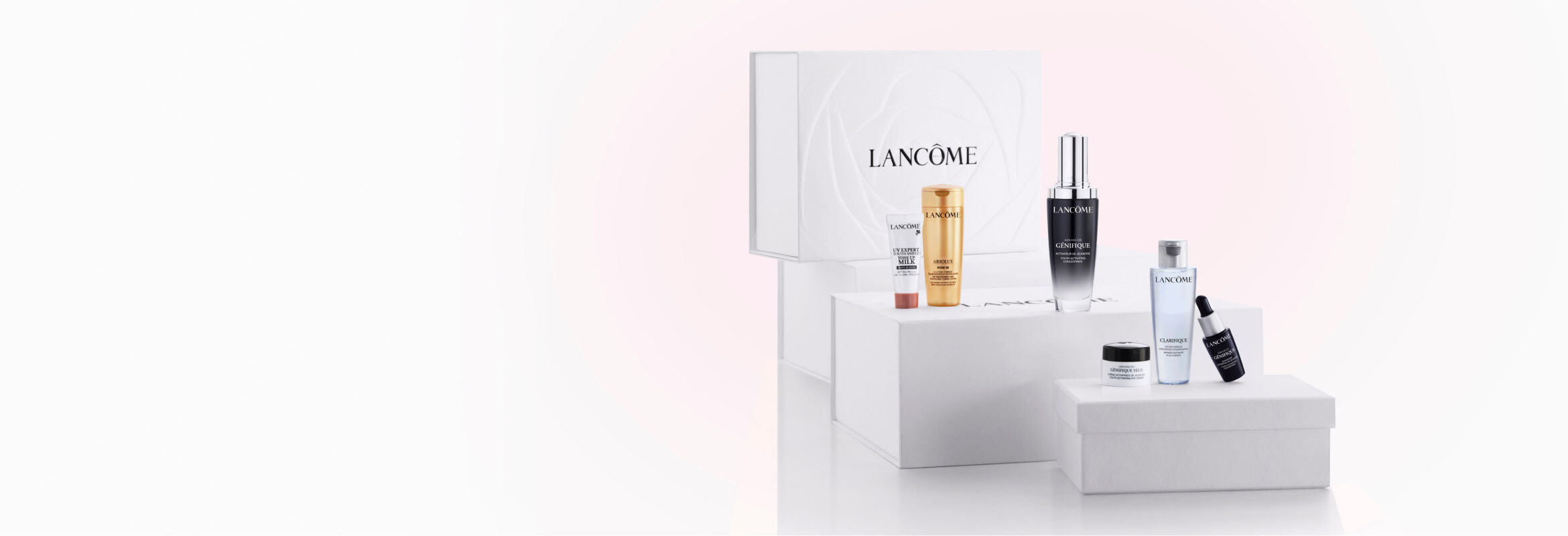 A display of Lancome skincare products, including various bottles and jars, arranged on white boxes with a minimalistic background featuring the Lancome logo.