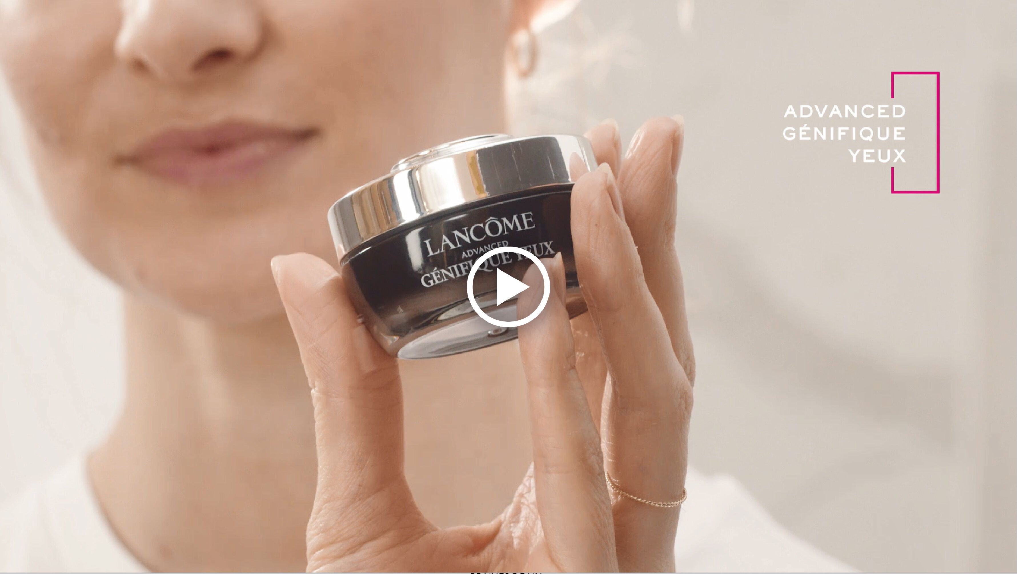 Une femme presente le soin contour des yeux Lancome Advanced Genifique, mettant en avant son efficacite.
