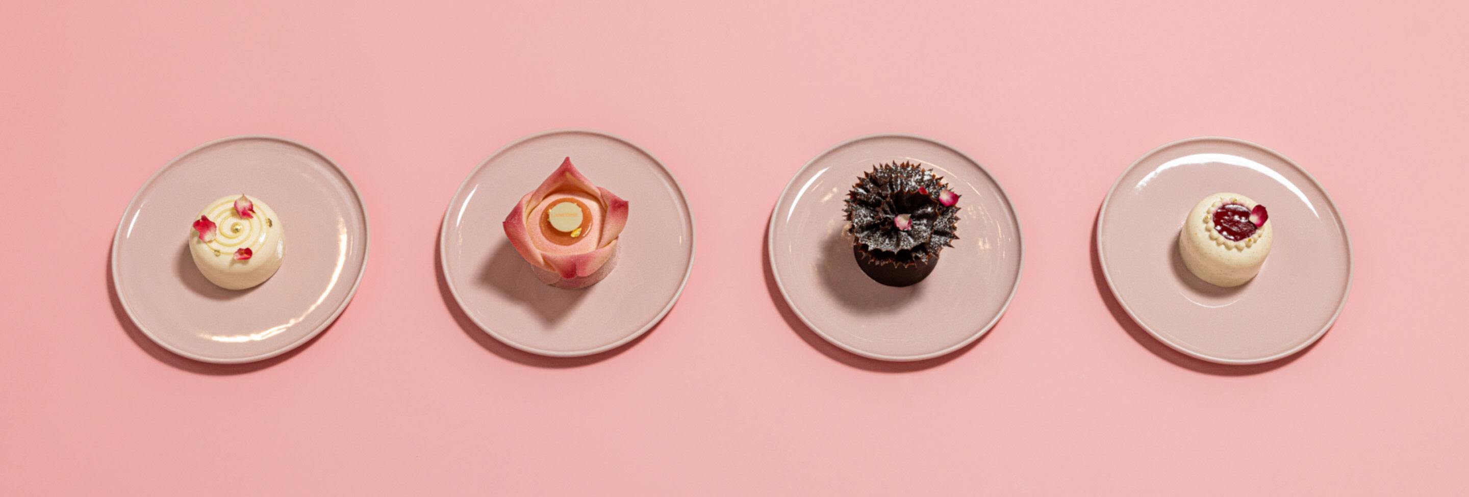 Une serie de desserts colores presentes sur des assiettes blanches.