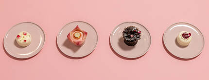 Une serie de desserts colores presentes sur des assiettes blanches.