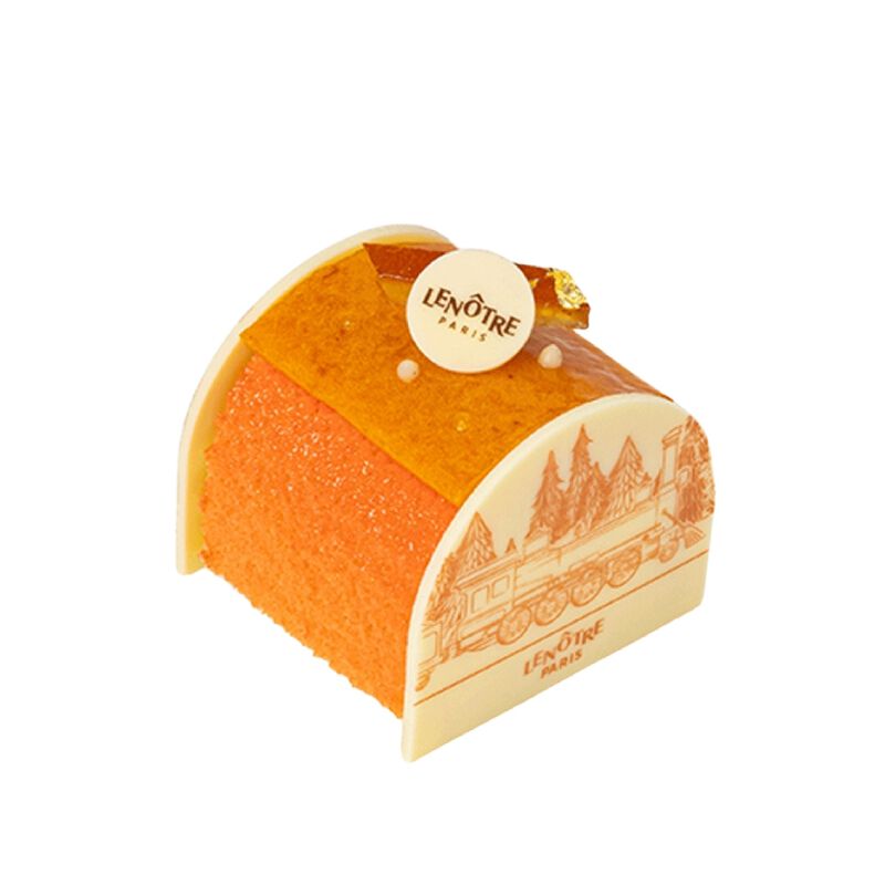 Une petite buche elegante glacee a l'orange avec une base en chocolat blanc et un petit element decoratif sur le dessus.