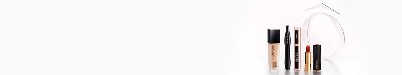 Three Lancome skincare products are displayed against a soft gradient background. The products include a black serum, a blue jar labeled "Renergie H.P.N. 300-Peptide Cream," and a gold jar labeled "Absolue Soft Cream."