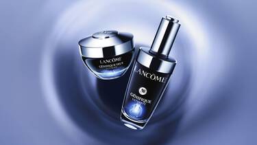 Une personne avec des taches de rousseur applique une creme blanche sur sa joue.