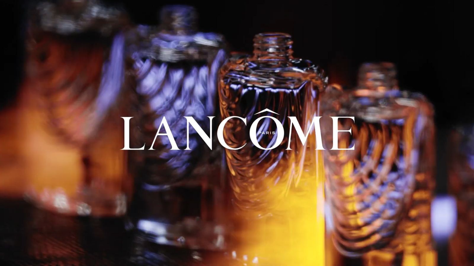Bouteilles de parfum Lancome en arriere-plan avec un eclairage elegant, mettant en avant le logo de la marque.