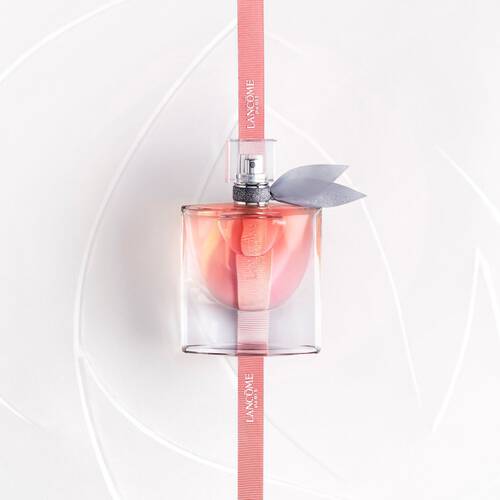 Flacon de parfum elegant de Lancome, pose sur un fond blanc, avec un ruban rose et un noeud gris.