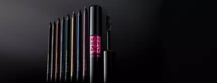 A collection of colorful eyeliners and a mascara, displayed against a dark background, highlighting the products' sleek packaging.