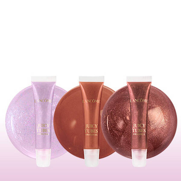 Trois gloss a levres de couleurs differentes sur un fond rose.