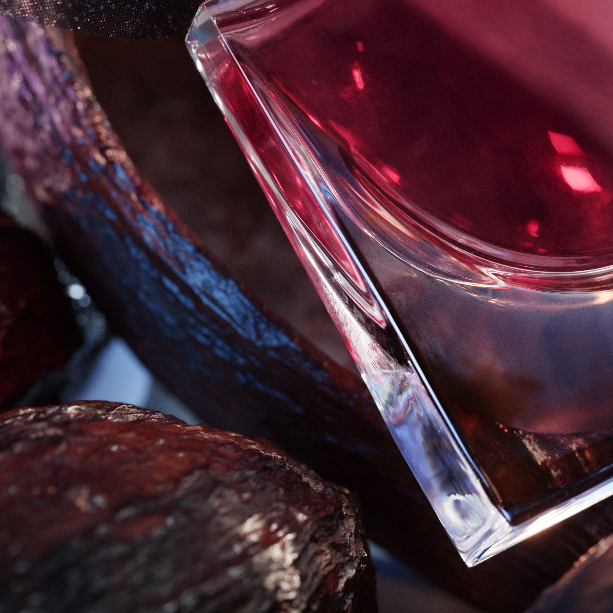 Flacon de parfum élégant sur un fond texturé, mettant en valeur des teintes profondes et des reflets lumineux.