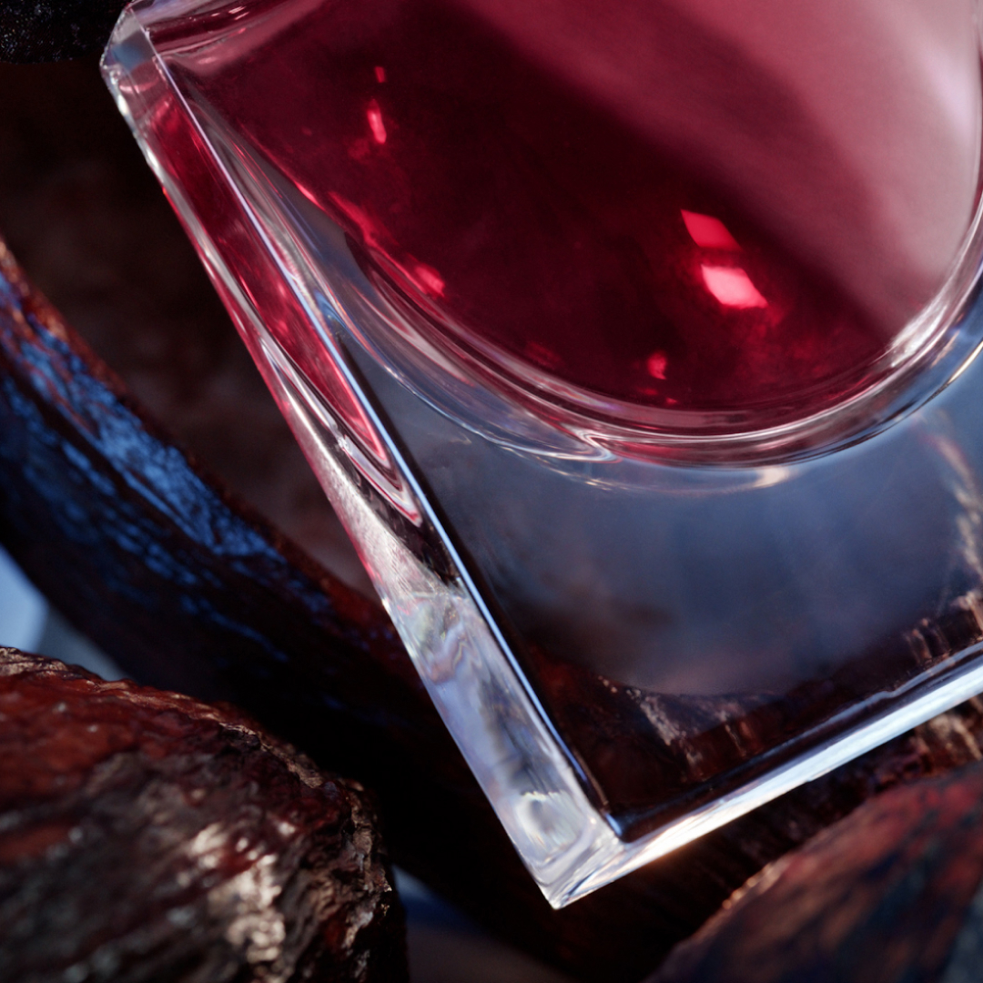 Flacon de parfum élégant sur un fond texturé, mettant en valeur des teintes profondes et des reflets lumineux.