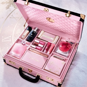 Flacon de parfum élégant, transparent avec une teinte rosée et un capuchon en métal, posé sur un fond blanc.