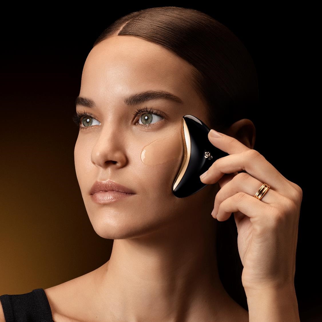 Fleur lumineuse en transparence, émettant des éclats dorés sur fond sombre, évoquant la beauté délicate et l'élégance.