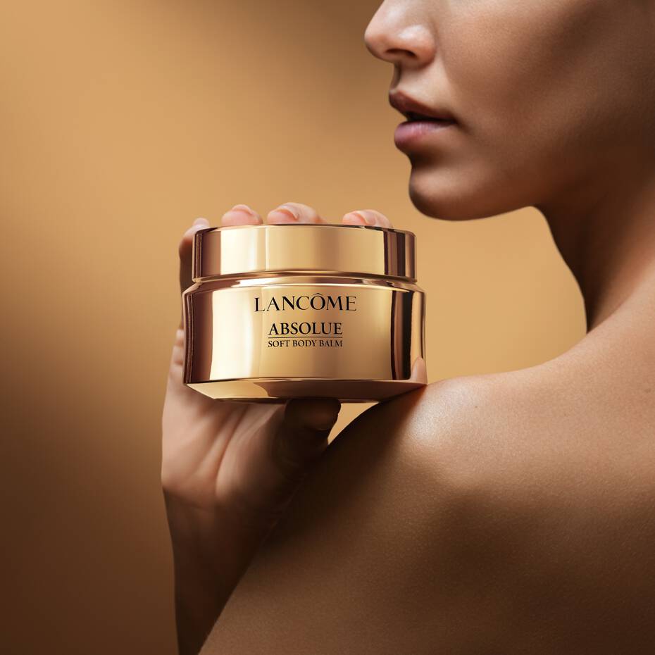 Une goutte d'huile dorée tombe dans une rose, créant un effet lumineux et raffiné qui évoque la beauté et la pureté.